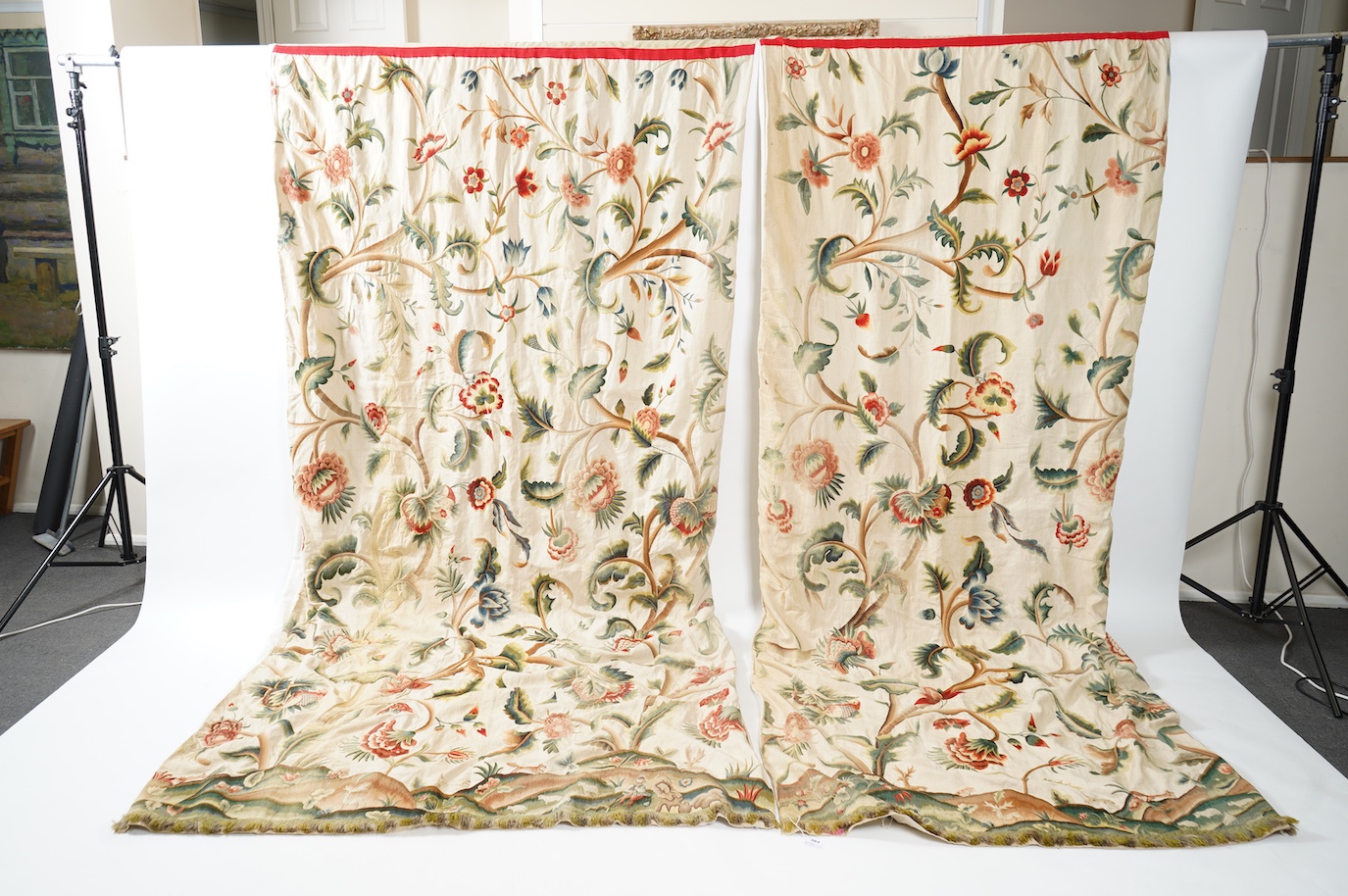 Six 20th century crewel work ‘Tree of Life’ cream linen curtains. Worked at the base in coloured wools depicting a pastoral scene of a shepherd playing a flute amongst sheep, deer, squirrels and flowers with a dog chasin
